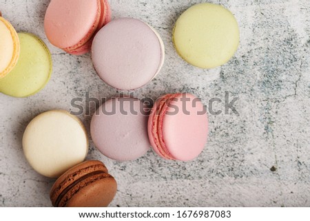 French macaroni cookies of different colors are on the gray table. Still life of confectionery.