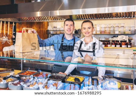 Small business and to go service concept due to isolation emergency with young restaurant owners working hard for take away food orders and deliveries to clients staying at home in quarantine Royalty-Free Stock Photo #1676988295