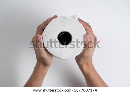 Both hand holding a roll of toilet paper with isolated white background. Toilet rolls become precious during the coronavirus season. 