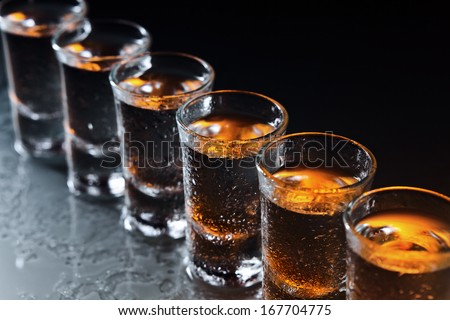 Glasses with an alcoholic drink on a damp glass table Royalty-Free Stock Photo #167704775
