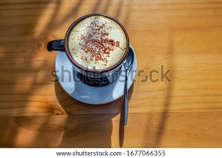 Top view a cup of Egg coffee  on wood background.Famous traditional Vietnamese coffee in Ha Noi, Vietnam. Eggs are beaten with coffee, hot drink or with ice