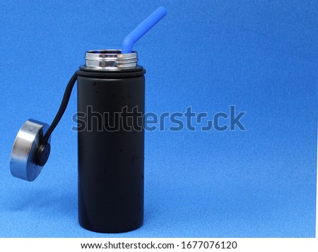 Steel bottle for water blue background and silicone straws