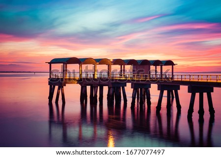 A beautiful ocean dramatic sunset and fishing pier at Jekyll Island in coastal Georgia, USA. Royalty-Free Stock Photo #1677077497