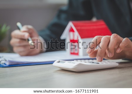 women using calculator to count rent, Calculating mortgage, loan or investment.Buying and selling houses and real estate prices concept.