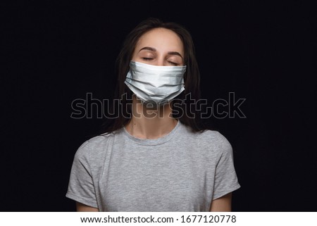 Calm woman in protective mask on black background. Prevention against pneumonia, keep on being on quarantine, staying home. Chinese coronavirus treatment. Healthcare, medicine, isolation concept.