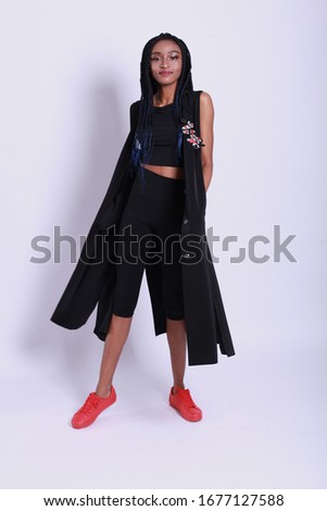 african cheerfull model wear black crop top and leggins. skinny body shape makeup cosmetic summer collection studio catalog accessory clothes for casual dress code fashion. studio photography
