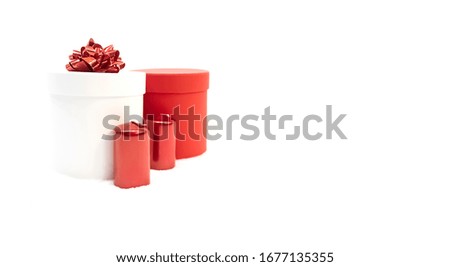 Cylindrical red holiday gift box, white cylindrical gift box with a red bow for woman on a white background with red candles, Valentine's day, Christmas or mother day, womens day.