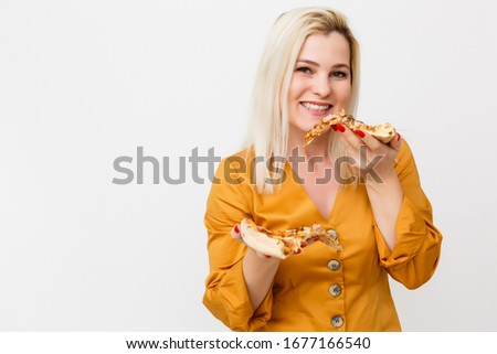beautiful blond woman eatting piece of pizza