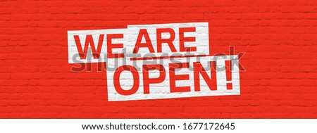 We are open on red brick wall