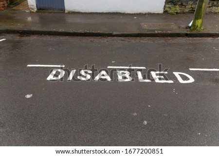 A close up view of a disabled parking area that has been marked off on the tar 