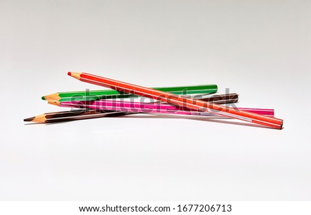 still life of colored paint pencils on white background
