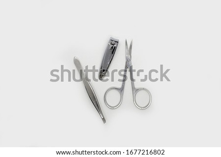 Manicure on a white background. Manicure scissors, eyebrow tweezers and nail clippers.