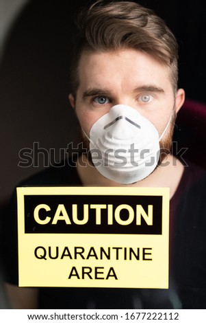 Coronavirus, quarantine and pandemic concept. Sad and sick man of corona virus looking through the window.