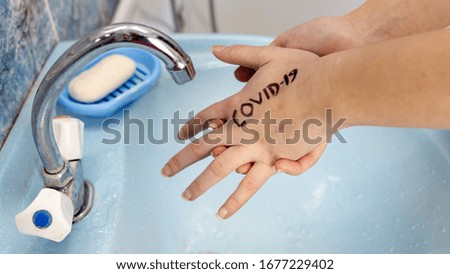 Hands with covid-19 written on them. Dangerous touch concept, prevent spread of virus, wash your hands with soap
