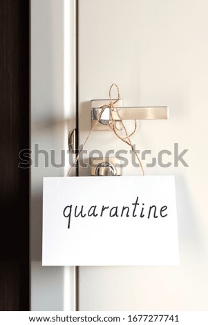 On the door handles a sign on paper with the signature Quarantine. The concept of self-isolation during a pandemic and epidemic. Vertical frame orientation.