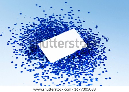 Stock Photo - Photo of blank card with blue sequins on  paper background. For design presentations and portfolios.