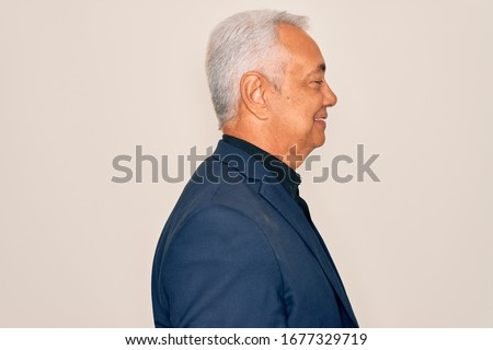 Middle age senior grey-haired handsome man wearing elegant business jacket looking to side, relax profile pose with natural face with confident smile.