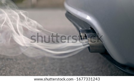 Smoky exhaust pipes from a starting diesel car. Royalty-Free Stock Photo #1677331243