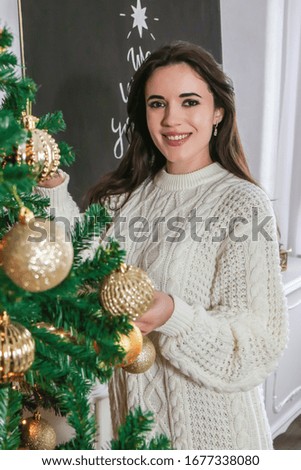 Happy woman decorate Christmas tree at home