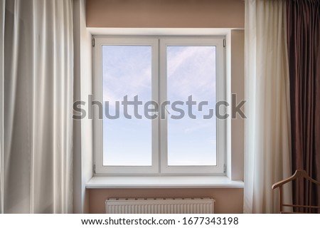 White window in the living room with blue cloudy sky