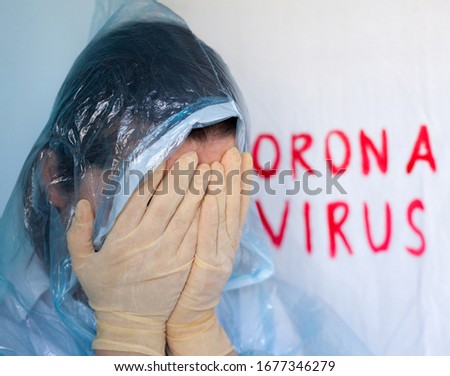 Woman in a protective suit closing her face. Inscription Coronavirus in the background. Coronavirus (Covid-19) disease outbreak.  Royalty-Free Stock Photo #1677346279