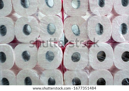 A large stack of toilet paper. A stockpile toilet paper with pink print in packaging. Concept of hoarding products due to coronavirus pandemic Royalty-Free Stock Photo #1677351484