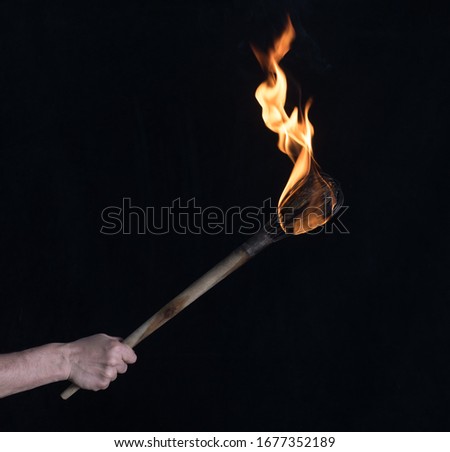wooden burning torch on a black background Royalty-Free Stock Photo #1677352189