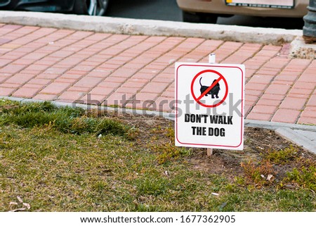 Don't walk the dog rectangular sign installed in grass. Park. City. Outdoor. Animals. Clean. Nature. Restriction. Pet. Walking. Sidewalk. Street. Urban. Public place