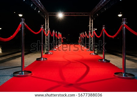 Red carpet with barriers and red ropes. Royalty-Free Stock Photo #1677388036