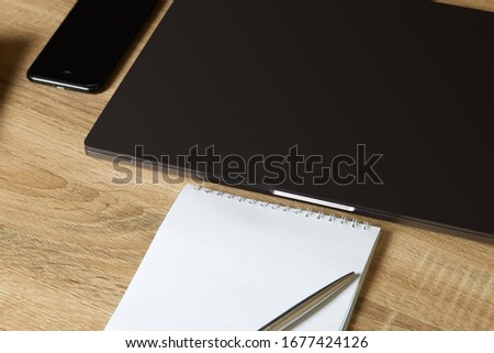 Remote work laptop phone notepad with pen on the table