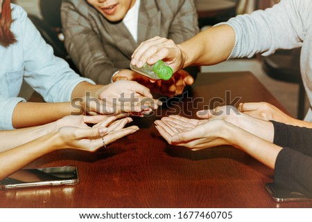 Group of business people in the office used a gel containing alcohol to clean hands to kill virus germs Coronaviral infection (COVID-19) Royalty-Free Stock Photo #1677460705