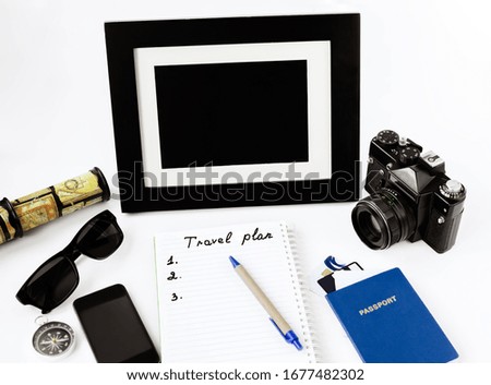 notebook with pen, passport, phone, camera and photo frame on a white background, close-up