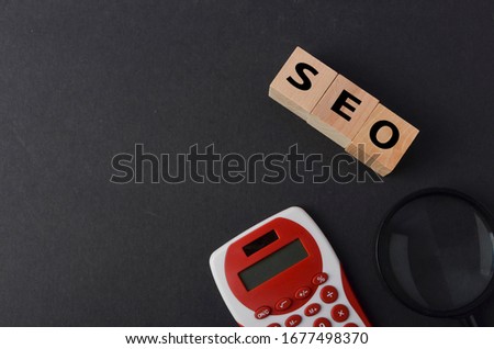 SEO text on wooden cubes on black background. Selective focus.
