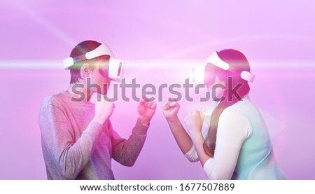 Couple with virtual reality headset are playing game and fighting. Concept of virtual reality, games, entertainment and communication.