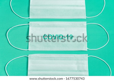 Surgical mask over minimalist green background