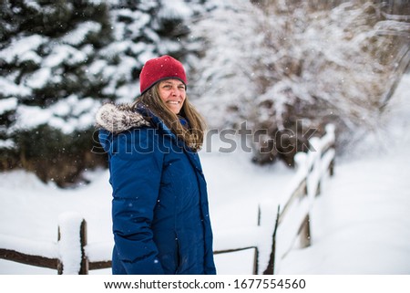 A very happy middle aged woman embracing cold winter weather in a wintery Vail, Colorado, USA