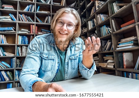 Smilng young man influencer blogger vlogger looking at camera recording educational training vlog or video calling by webcam speak communicating in online chat recording social media channel content. Royalty-Free Stock Photo #1677555421
