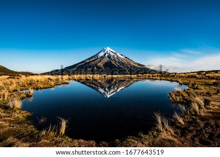 Mount Taranaki reflected in the clear water, New Zealand Royalty-Free Stock Photo #1677643519