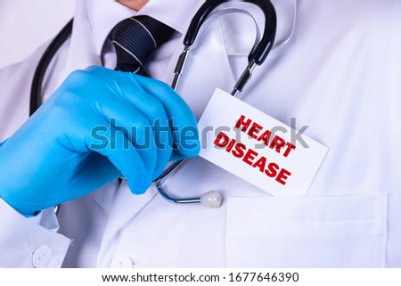 Doctor holding a card with text Heart Disease medical concept