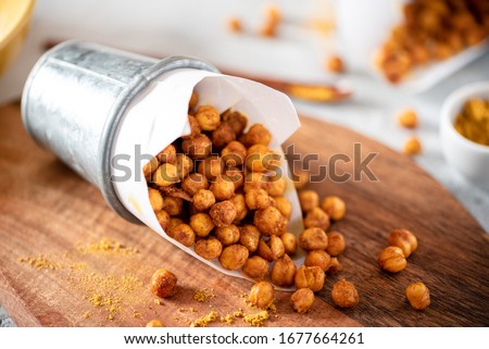 Spicy crispy roasted chickpeas with paprika, curry and hot chili pepper, selective focus. Tasty vegetarian and vegan chickpea snack. Royalty-Free Stock Photo #1677664261