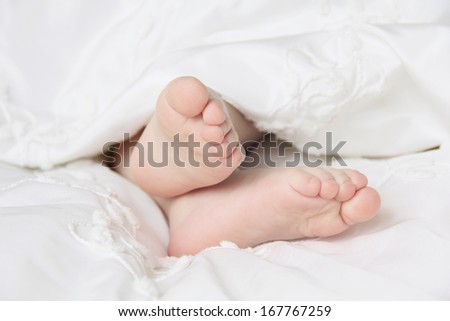 small foot sleeping baby in the crib