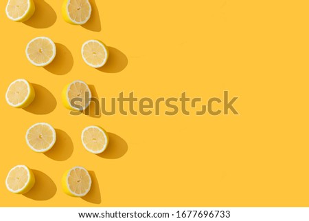 Fresh yellow lemon halfs pattern on yellow background. Copy space for text. Wallpaper, sale, discount, natural cosmetics banner background Royalty-Free Stock Photo #1677696733