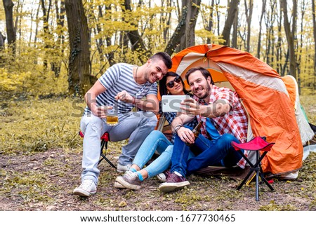 Friends taking a selfie while camping together