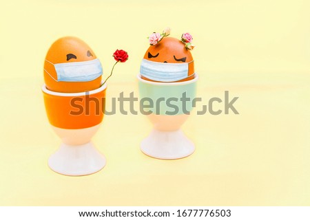 Happy easter eggs with drawn cartoon faces and with virus mask on light yellow background. Corona virus (COVID19) protection and Easter concepts in minimal style.