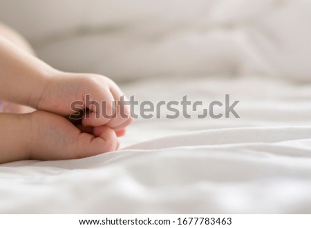 hands of a sleeping baby in the form of a heart on a white background. A child's dream