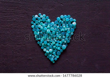 Heart Blue opal. A bunch of natural stones of blue opal lies on a black modern background. Natural stones, minerals to create jewelry. Beautiful turquoise natural stones. Copy space for your text.