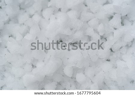 Closeup top view photography of white fresh hails particles laying on windowsill under heawy thunderstorm.