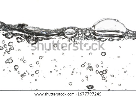 Clear white bubbles that exist both under the water and on the clear water surface. White background Royalty-Free Stock Photo #1677797245