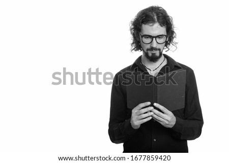 Portrait of handsome bearded businessman with eyeglasses reading book
