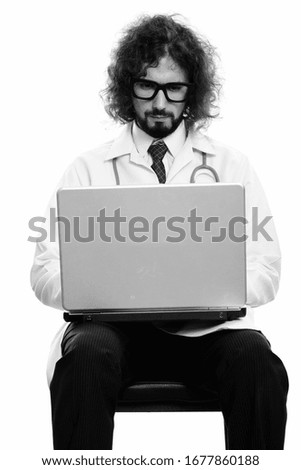 Studio shot of handsome man doctor using laptop
